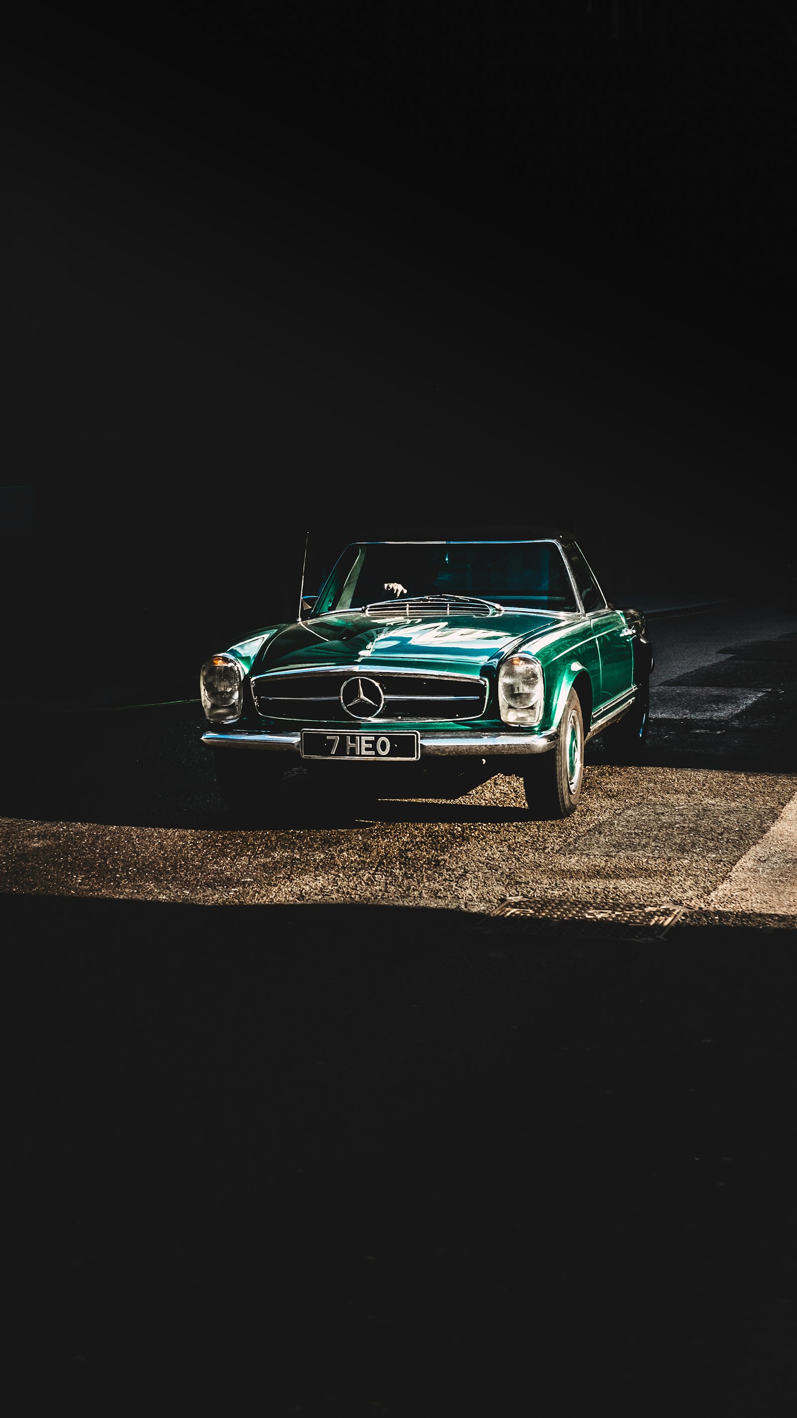 A green Mercedes-Benz coupe photographed in profile